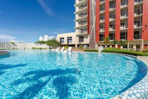 a large swimming pool in front of a building at Cozy and Nature-Inspired Studio Unit in Agus