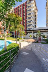 a walkway in front of a building with palm trees at Cozy and Nature-Inspired Studio Unit in Agus