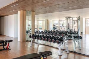 a gym with a lot of equipment in a room at Cozy and Nature-Inspired Studio Unit in Agus