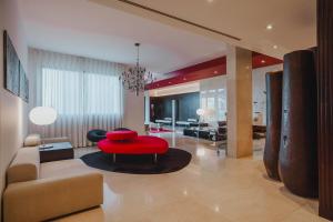 a living room with a red chair and a couch at Quinta Mirabela - Design Hotel in Funchal