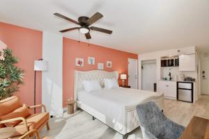 a bedroom with a white bed and a ceiling fan at Beach Studio with Partial Water Views Sundeck Pool in Daytona Beach