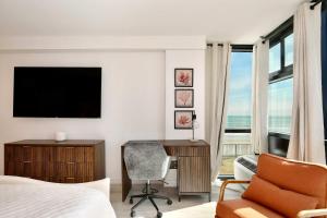 a bedroom with a bed and a desk and a chair at Beach Studio with Partial Water Views Sundeck Pool in Daytona Beach +21 photos
