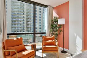 a living room with two chairs and a large window at Beach Studio with Partial Water Views Sundeck Pool in Daytona Beach