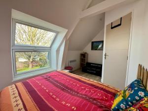 a bedroom with a large window and a bed at L'Erable - Maison vue mer in Donville-les-Bains