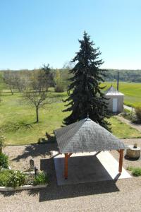 a picnic table with a tree in a field at Les Devants De Rupuanne in Bréhémont