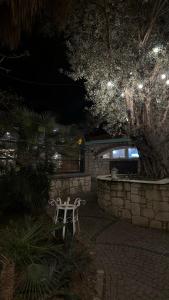a white bench sitting in a yard at night at Boreas Otel Alaçatı in Alaçatı