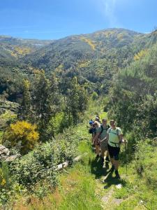 a group of people walking on a mountain trail at Quinta WOW in Benfeita