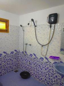 a shower in a bathroom with a blue and white wall at Dream Haven Mirissa in Mirissa