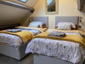 two beds in a attic room with a mirror at The Studio Gressingham in Hornby