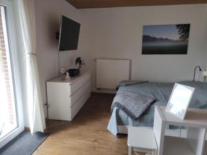 a bedroom with a bed and a tv and a table at Ferienwohnungen Mamat in Haltern