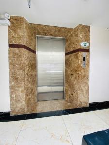 a lobby with a glass elevator in a building at ROSE Appartment in Ho Chi Minh City