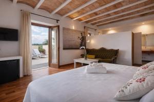 ein Schlafzimmer mit einem großen Bett und ein Wohnzimmer in der Unterkunft Hotel Can Riera by CheelHotels in Moscari
