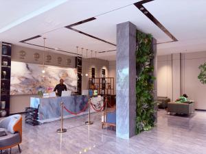 a lobby with a plant wall in the middle at Hotel Eden - 24 Novembre in Kinshasa