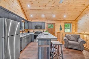 a kitchen with a stainless steel refrigerator and a chair at Sneaky Bear in Sevierville +30 photos