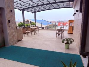 a patio with a table and chairs and a blue rug at Hotel Eden - 24 Novembre in Kinshasa