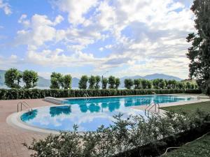 a swimming pool in a resort with mountains in the background at Parco Hermitage - Villa Azalea in Porto Valtravaglia