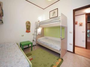a bedroom with two bunk beds and a green rug at Parco Hermitage - Villa Azalea in Porto Valtravaglia +13 photos