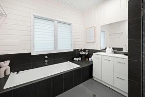a white bathroom with a tub and a sink at Garrys After Dunes Delight in Norah