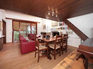 a living room with a table and a red couch at Parco Hermitage - Villa Azalea in Porto Valtravaglia