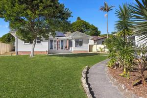 a white house with a palm tree in a yard at Garrys After Dunes Delight in Norah