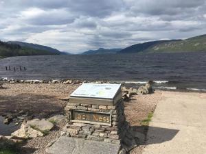 a sign on the shore of a body of water at Cosy flat in Inverness