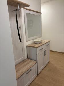 a bathroom with a vanity with a mirror and a door at Lima Apartment in Bernolákovo +4 photos