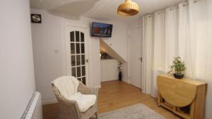a living room with a chair and a desk at Cosy flat in Inverness