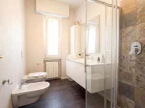 a bathroom with a toilet and a sink and a shower at Design Penthouse with Balcony - Iseo in Iseo +3 photos