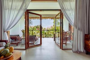 a living room with sliding glass doors and a balcony at Zanzibella Hotel & SPA in Kiwengwa
