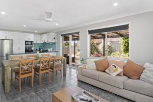 a living room with a couch and a table at Play and Pool Bonnells Bay in Bonnells Bay