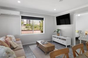 a living room with a couch and a table at Play and Pool Bonnells Bay in Bonnells Bay