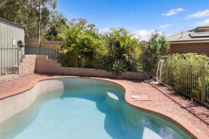a swimming pool in a yard with a fence at Play and Pool Bonnells Bay in Bonnells Bay