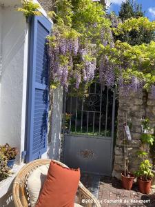a wreath of purple flowers hanging over a door at La Cachette de Beaumont in Marsais