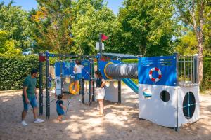 a group of people playing on a playground at Camping Le Bois Soleil - Mobil home 3 pièces 4 personnes + TV MAE-4364 in Les Sables-d'Olonne