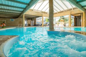 a swimming pool with blue water in a building at Camping Le Bois Soleil - Mobil home 3 pièces 4 personnes + TV MAE-4364 in Les Sables-d'Olonne
