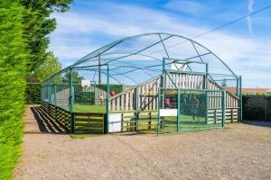 a large cage with a playground in a yard at Camping Le Bois Soleil - Mobil home 3 pièces 4 personnes + TV MAE-4364 in Les Sables-d'Olonne