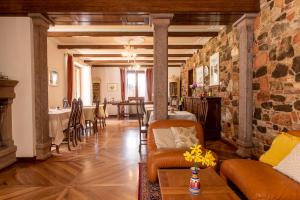 a living room with a stone wall and a table at Villa Montegenco B&B in Comunanza