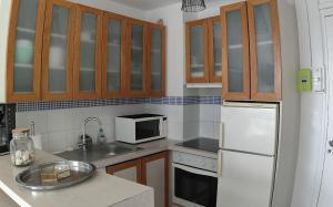 a kitchen with wooden cabinets and a white refrigerator at cote d'armor in Plestin-les-Grèves