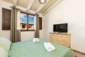 a bedroom with a bed and a tv on a dresser at Agorà Apartments in Villasimius