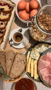 a table with bread and eggs and a cup of coffee at Logis Hôtel La Cascade - Lyon Nord in Saint-Genis-les-Ollières