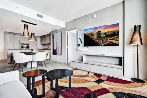 a living room with a tv on a wall at 3BR Oceanview HYDE - Free Parking, No Resort Fee in Hollywood +39 photos