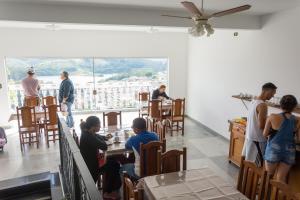 un grupo de personas sentadas en mesas en un restaurante en Pousada Lourenço, en Nazaré Paulista