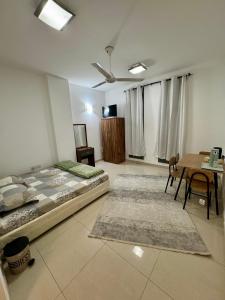 a bedroom with a bed and a table and chairs at Farno Hostel in Muscat