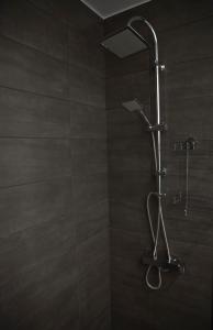 a shower with a shower head in a bathroom at GK Athens by GK Hospitality Group in Athens
