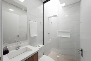 a white bathroom with a sink and a shower at Alto padrão, 2 suítes e lazer privativo in Joinville +31 photos
