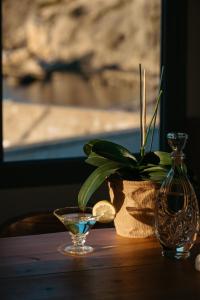 a table with a glass vase and a plant on it at Irini's Beach House in Ambrami