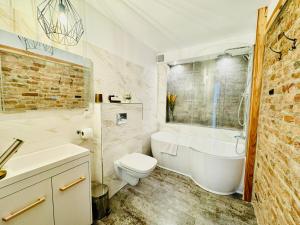 a bathroom with a tub and a toilet and a sink at Jazz House in Voroneţ +62 photos
