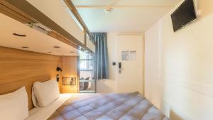 a bedroom with a bed and a window at Premiere Classe Marne la Vallée - Torcy in Torcy