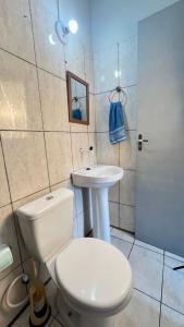 a bathroom with a white toilet and a sink at Casa próxima ao Centro de Foz in Foz do Iguaçu +23 photos