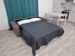 a bedroom with a bed and a table and a kitchen at Il Mirto, Residenza Privata in Bacu Abis